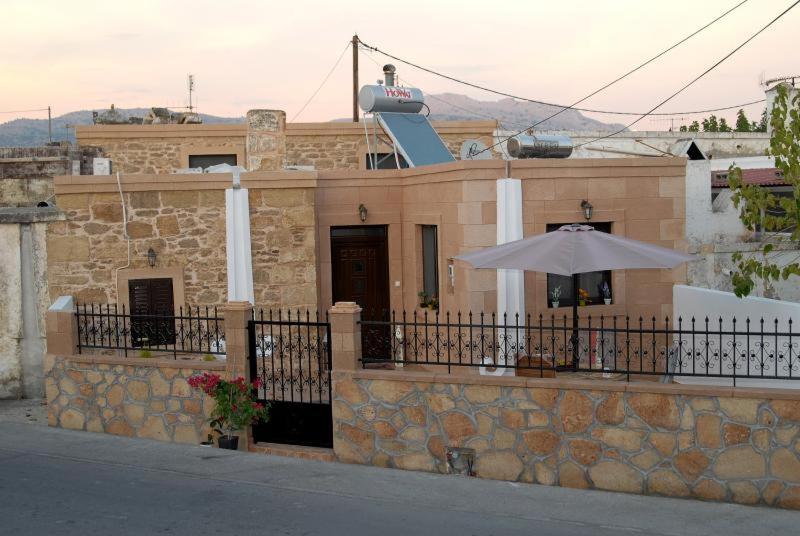 ハラキにあるtraditional villa aphroditeの傘の前の建物