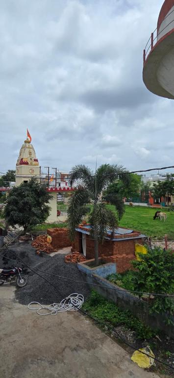 a park with palm trees and a building in the background at Muskan home stay in Ujjain