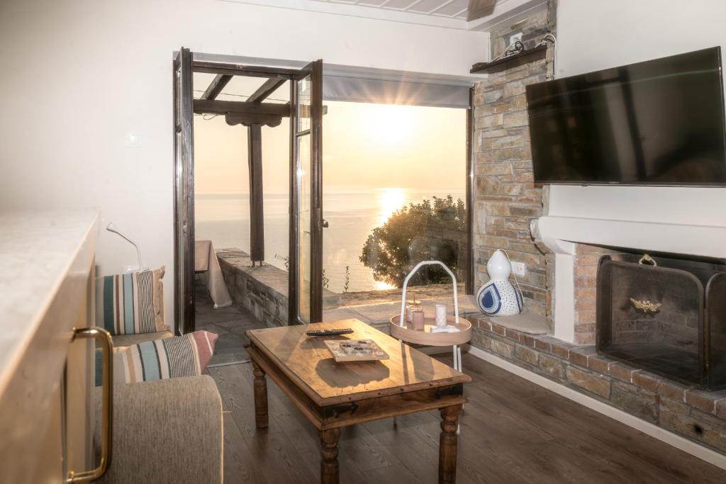a living room with a fireplace and a tv at The Pelion Sunrise in Agios Ioannis Pelio