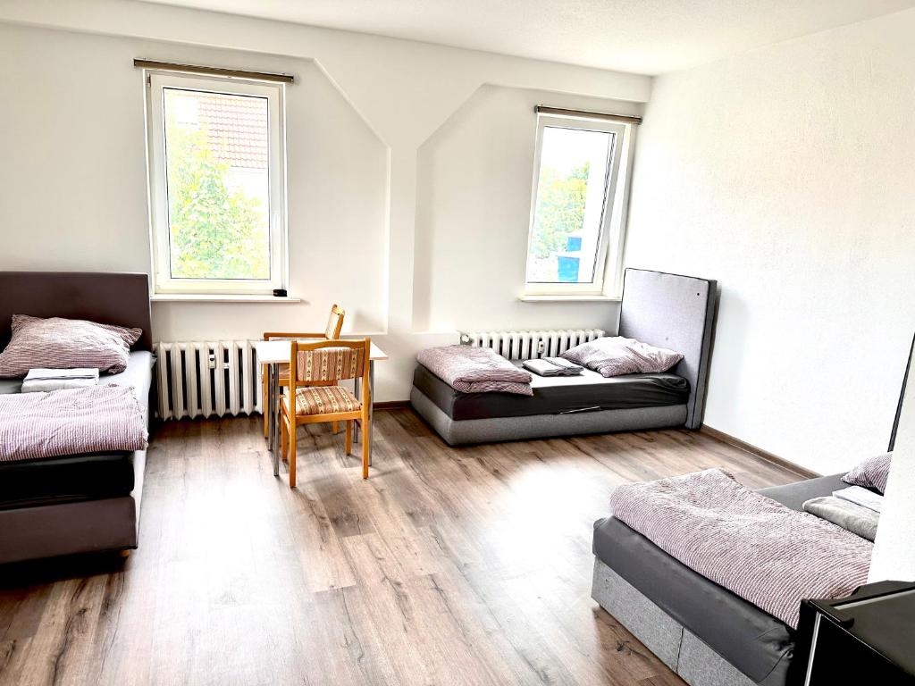 uma sala de estar com duas camas e uma mesa em Pension Jasmin A em Chemnitz