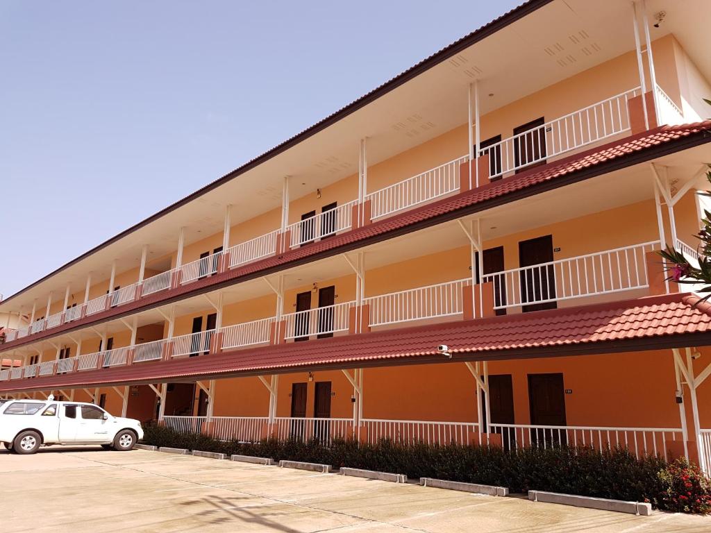 un edificio con balcones y coches aparcados en un aparcamiento en Cordelia Chiangrai, en Chiang Rai