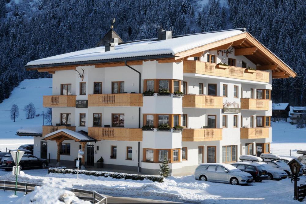duży budynek z samochodami zaparkowanymi na parkingu w obiekcie Jagdhof Ligedl w Mayrhofen