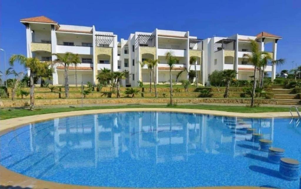 a large swimming pool in front of a building at Marina Golf Asilah in Asilah
