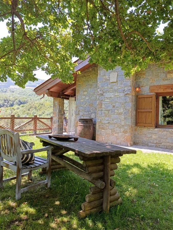 a picnic table and a bench in front of a building at Les Pedres in Camprodon