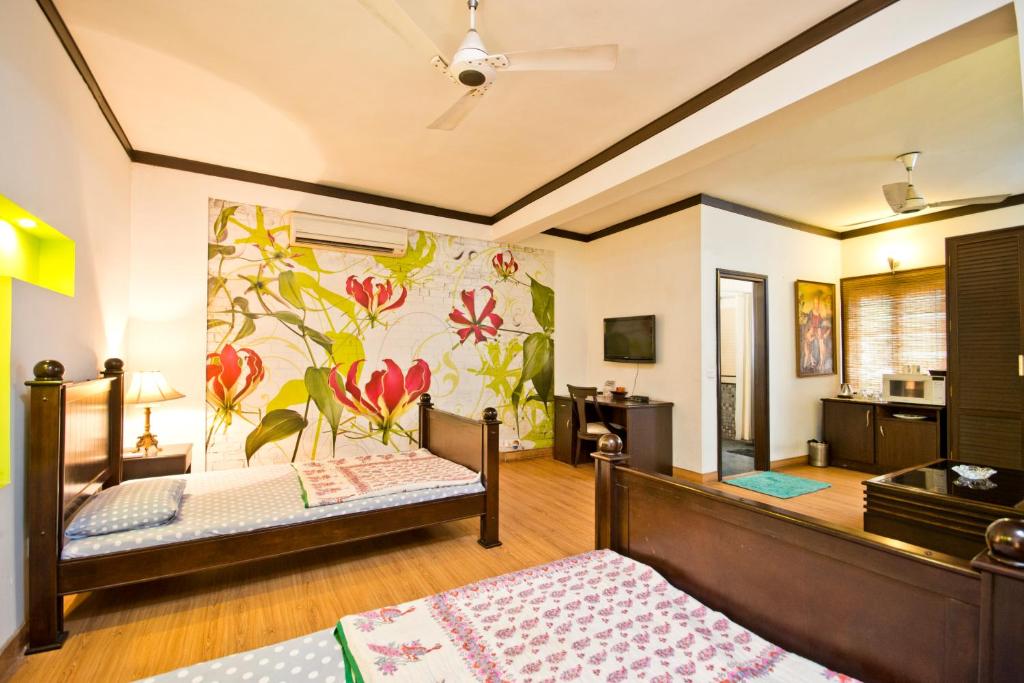 1 dormitorio con 2 camas y un mural de flores en Trendy Bed & Breakfast, en Nueva Delhi