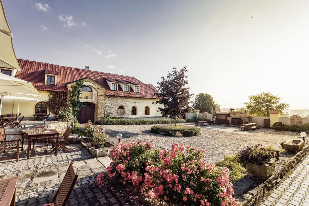 a house with a patio with a table and flowers at Hotel Rytířsko in Jamné