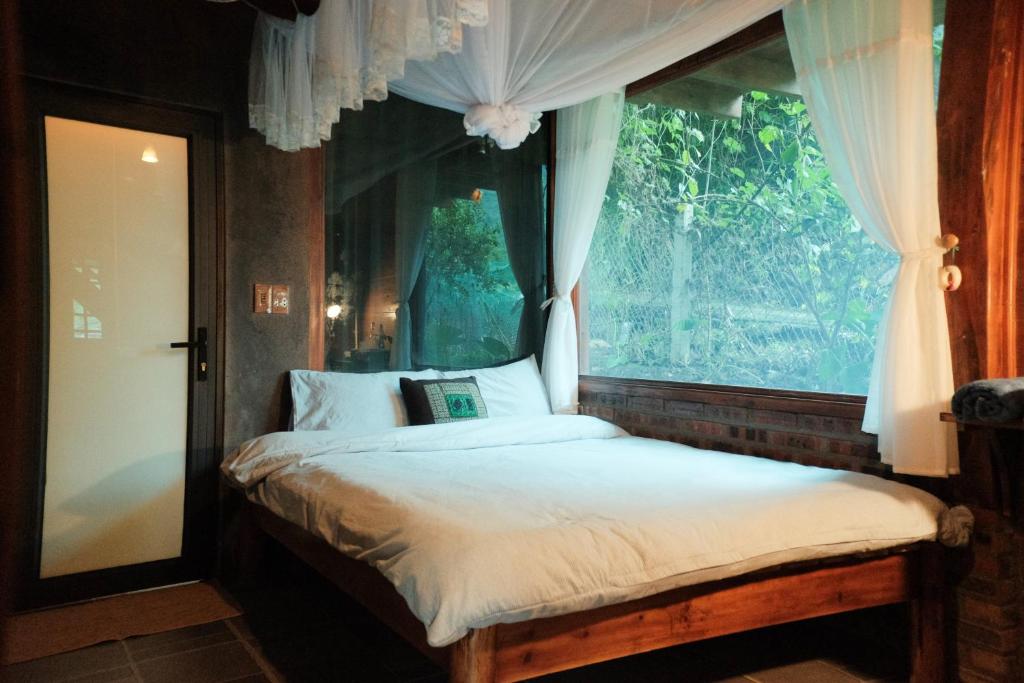 a bed in a room with a window at Nương Homestay in Sa Pa