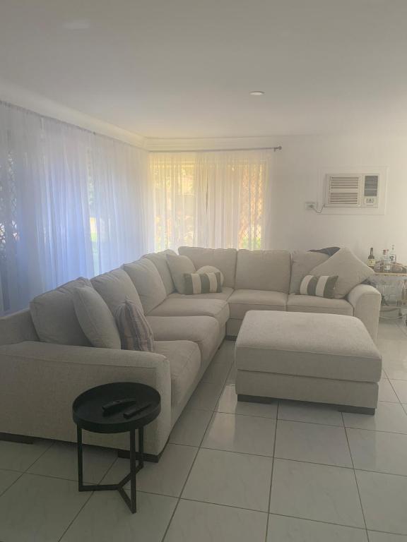 a white living room with a couch and a table at Serenity stay in Perth