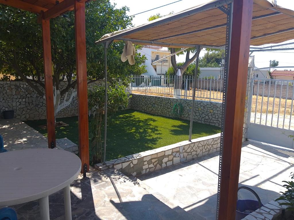 a backyard with a gazebo and a green lawn at Ledjon apartament in Artemida