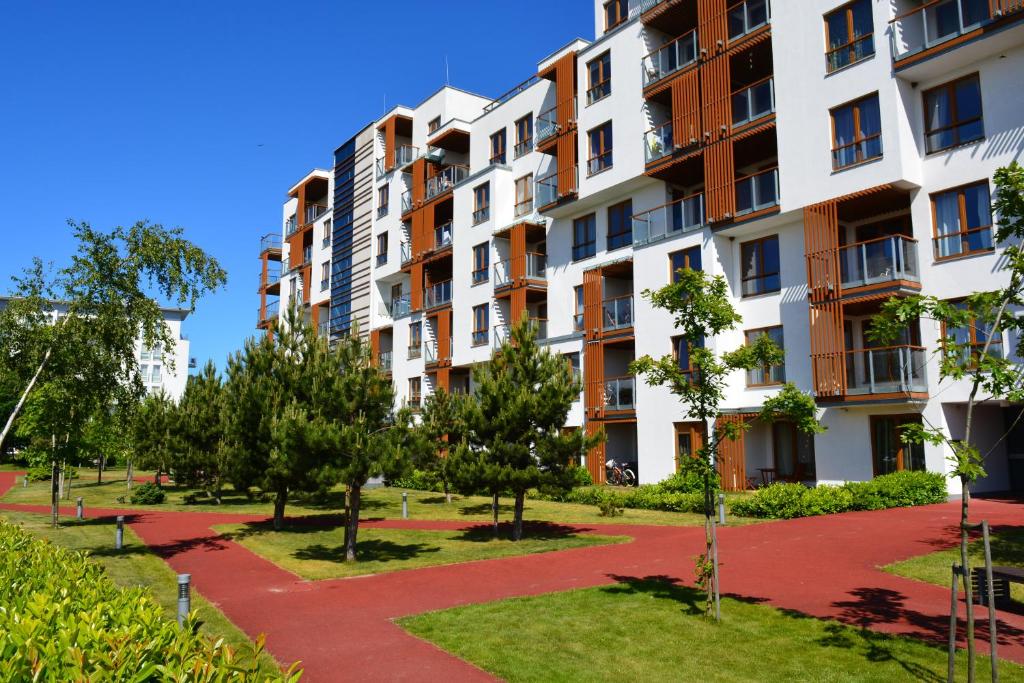 コウォブジェクにあるApartamenty PROMENADA - Olimpic Parkの公園内の木々のあるアパートメントビル