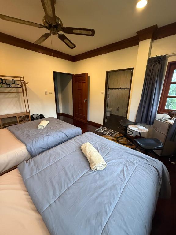 a bedroom with two beds and a ceiling fan at Sweet home in Bangrak Beach