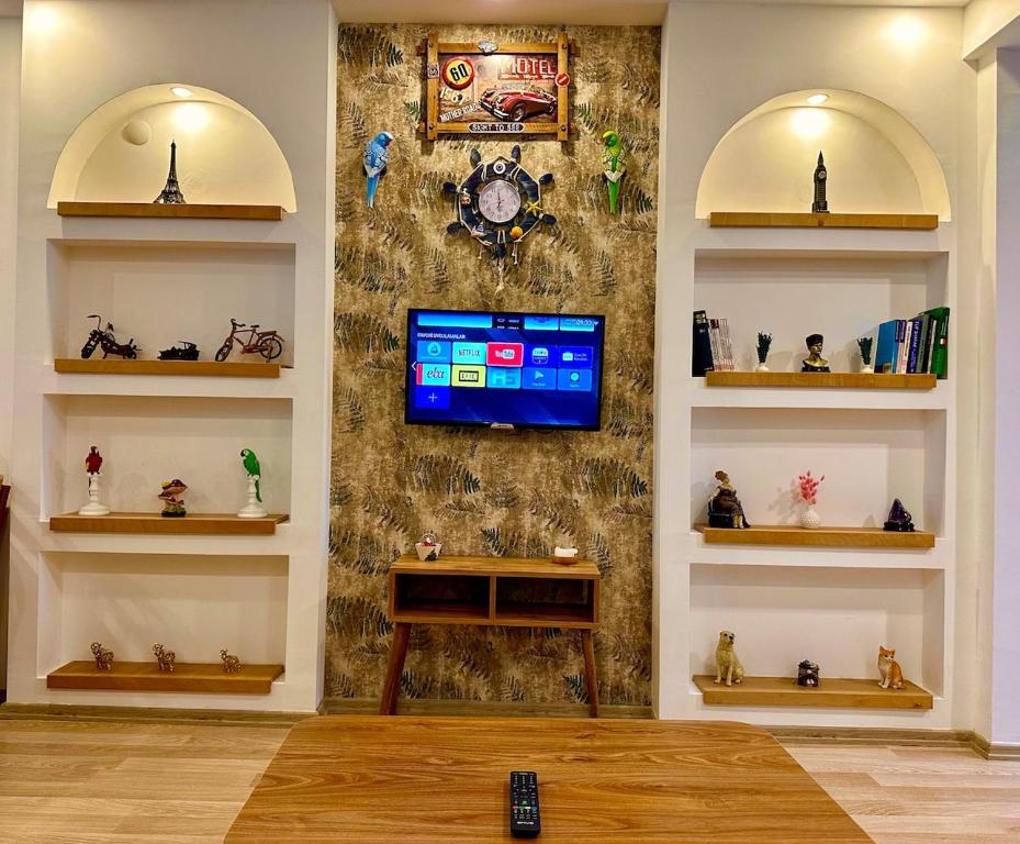 a living room with a tv on a wall with shelves at Villa Maldives, right on sea in center of Fethiye in Fethiye