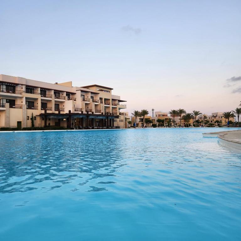 a swimming pool in front of a resort at Blanca, Marassiمراسي العلمين in El Alamein