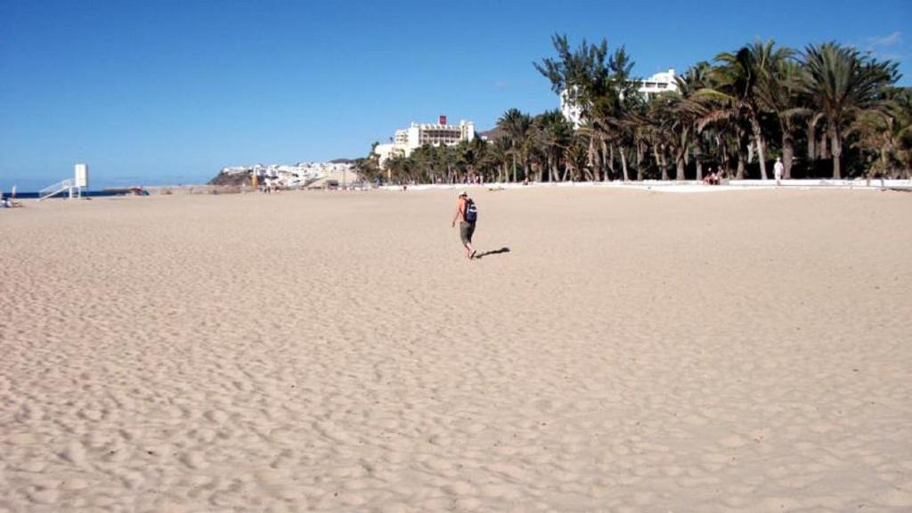モロ・デル・ハブレにあるJandia Attico Vista Oceanoのフリスビーを持って海岸を歩く男