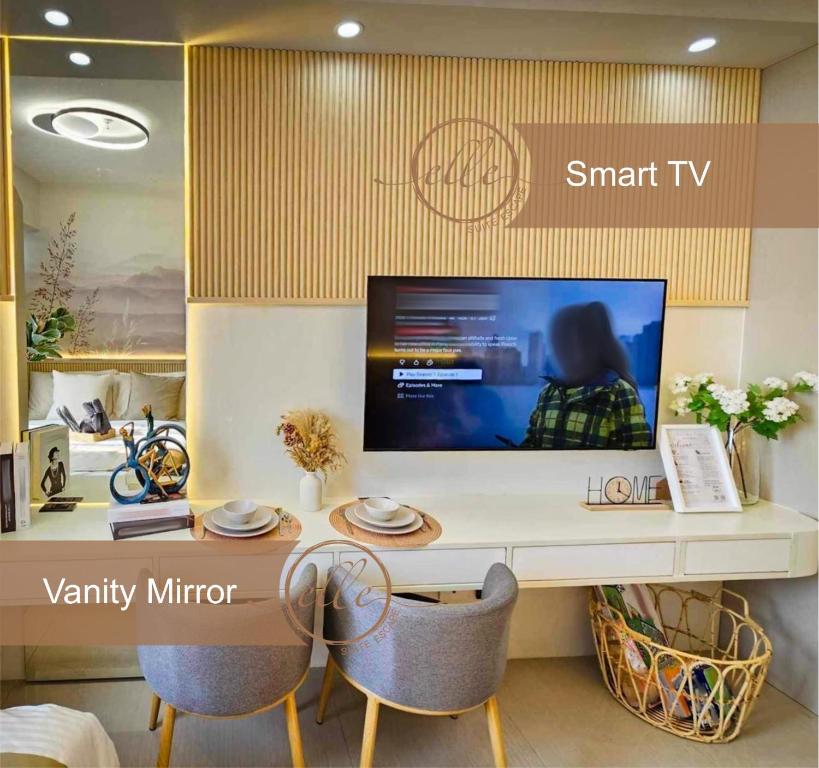a tv sitting on top of a desk with two chairs at Modern Unit at Shore 2 Mall of Asia by Elle Suite in Manila