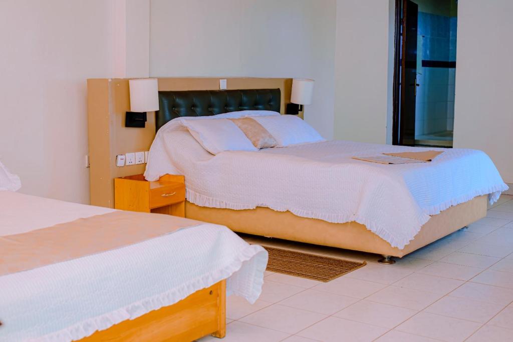 Un dormitorio con dos camas en una habitación. en Quality Inn Motel, Nyanza, en Gahondo