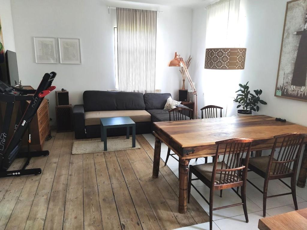a living room with a table and a couch at Hilltop view - 2 bedroom house with garden bbq - private parking - 12min to Uzupis anytime in Vilnius