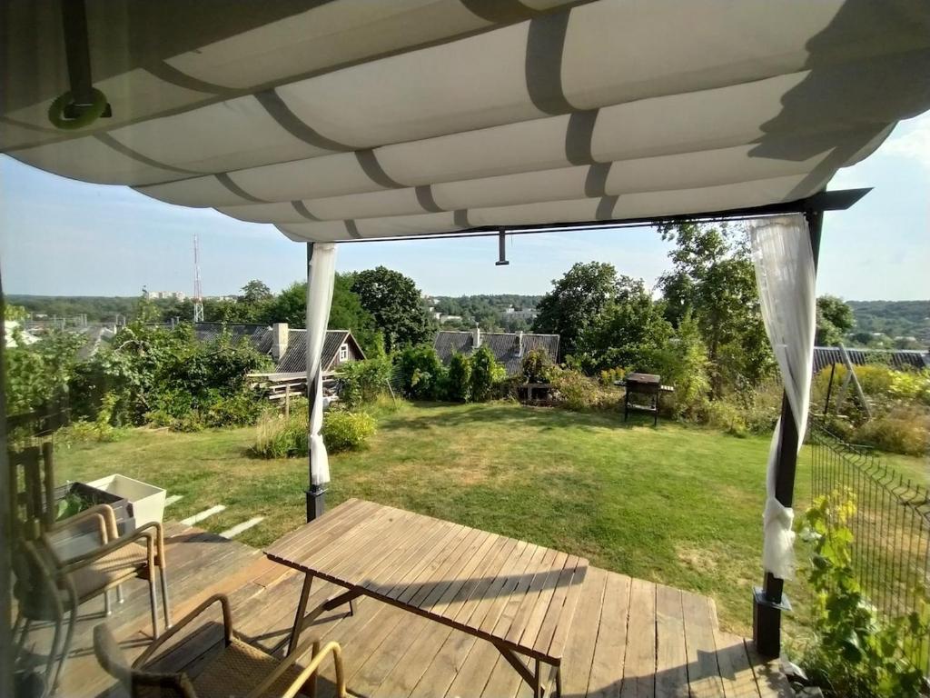 a patio with a table and chairs under a white umbrella at Hilltop view - 2 bedroom house with garden bbq - private parking - 12min to Uzupis anytime in Vilnius