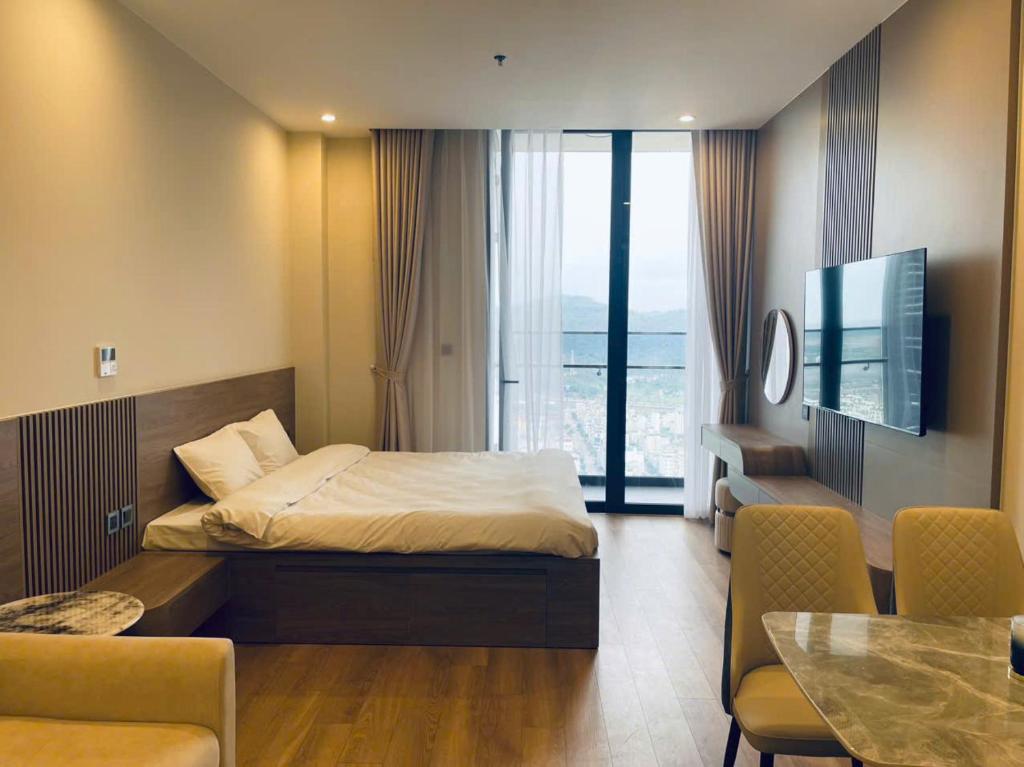 a hotel room with a bed and a dining room at Home Stay ICON40 Hạ Long Khách sạn cao cấp in Ha Long