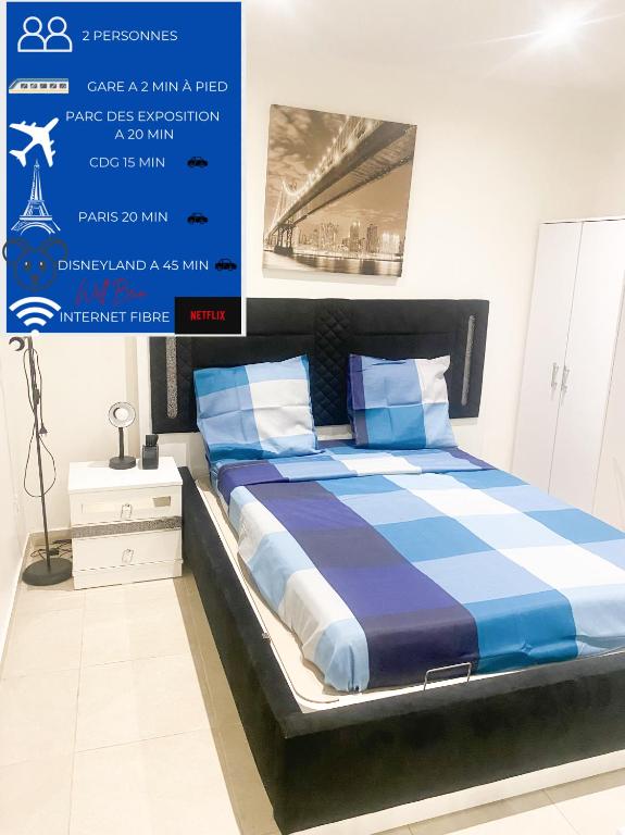 une chambre avec un lit avec des draps bleus et blancs dans l'établissement Logement à 20 mins de paris , Stade 2 France, Aéro CDG, Parc des expositions, à Arnouville-lès-Gonesse