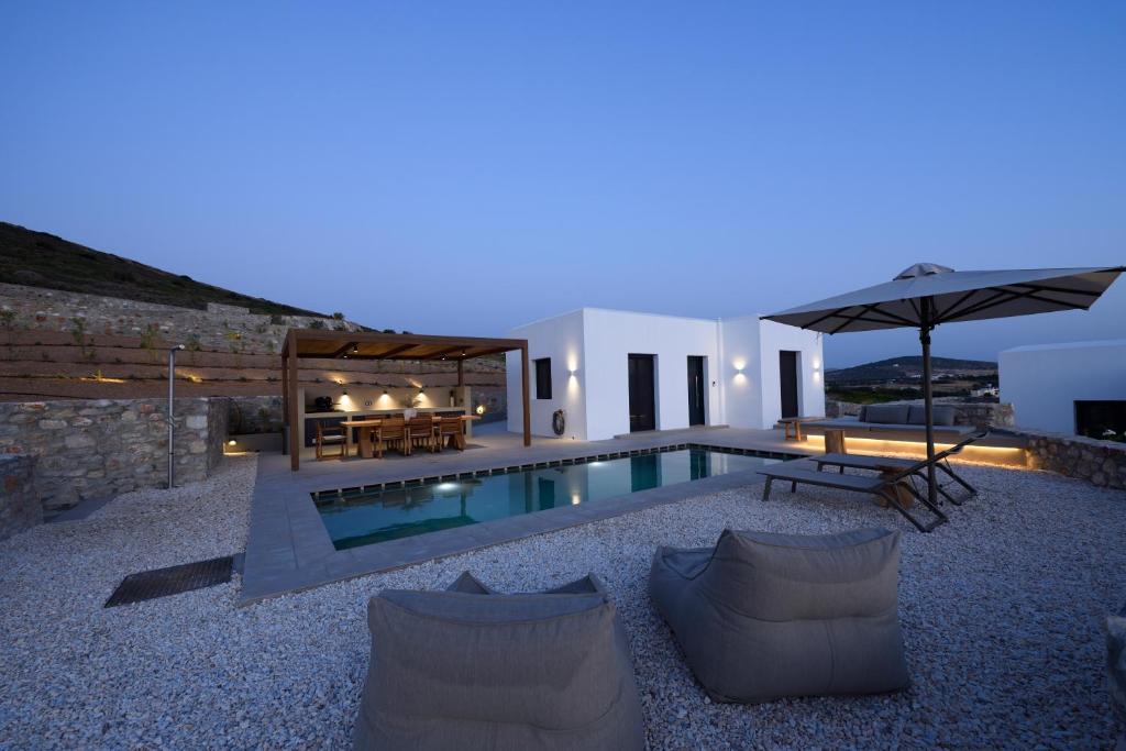 a villa with a swimming pool at night at ANOTERRA VILLAS -Anassa in Ambelas