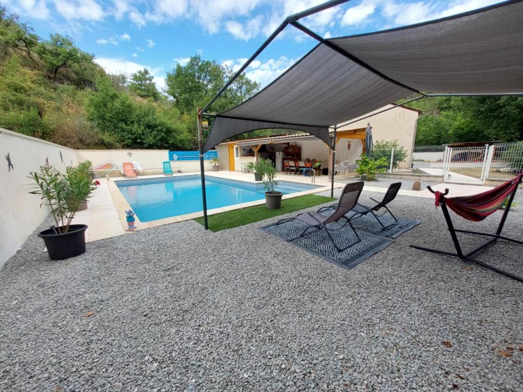 a patio with two chairs and a swimming pool at Gîte Orléo Sérénité in Saint-Vincent-Rive-dʼOlt