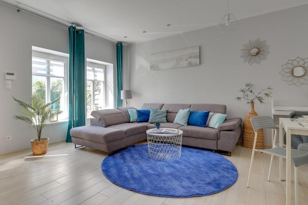 a living room with a couch and a blue rug at Haffnera 19 - Sea & City Moments by Lion Apartments Sopot in Sopot