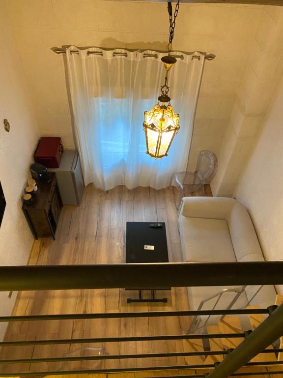 a living room with a couch and a laptop on a table at En Camargue, Gite Cosy climatisé jacuzzi en sus, proche lac et mer in Vauvert
