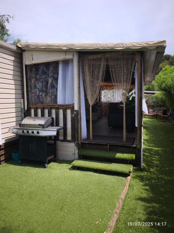 une maison avec un porche avec un grill et de l'herbe dans l'établissement Oasis Louisitanienne, à Hyères