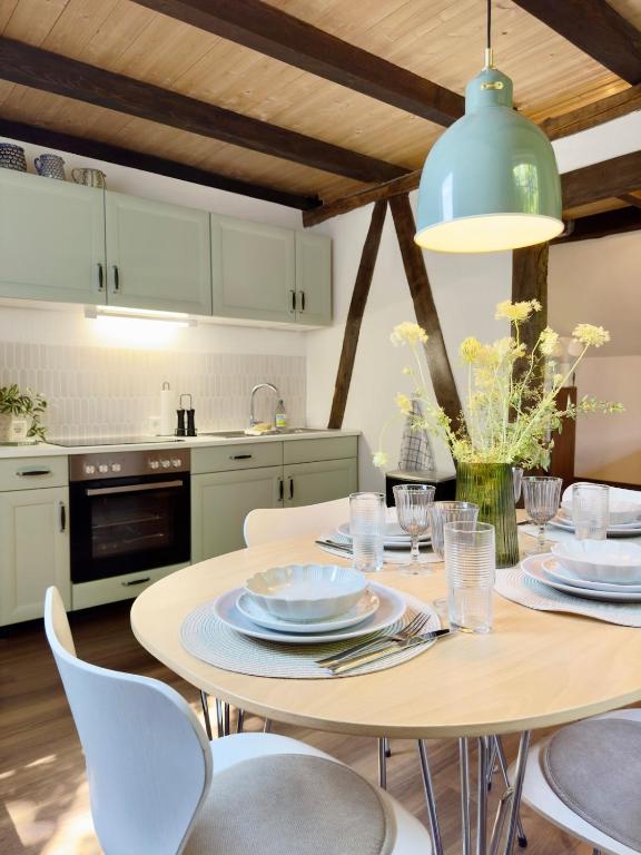 a kitchen with a table with plates and chairs at Alte Dorfschmiede - idyllische Ferienwohnung in Meschede-Calle in Meschede