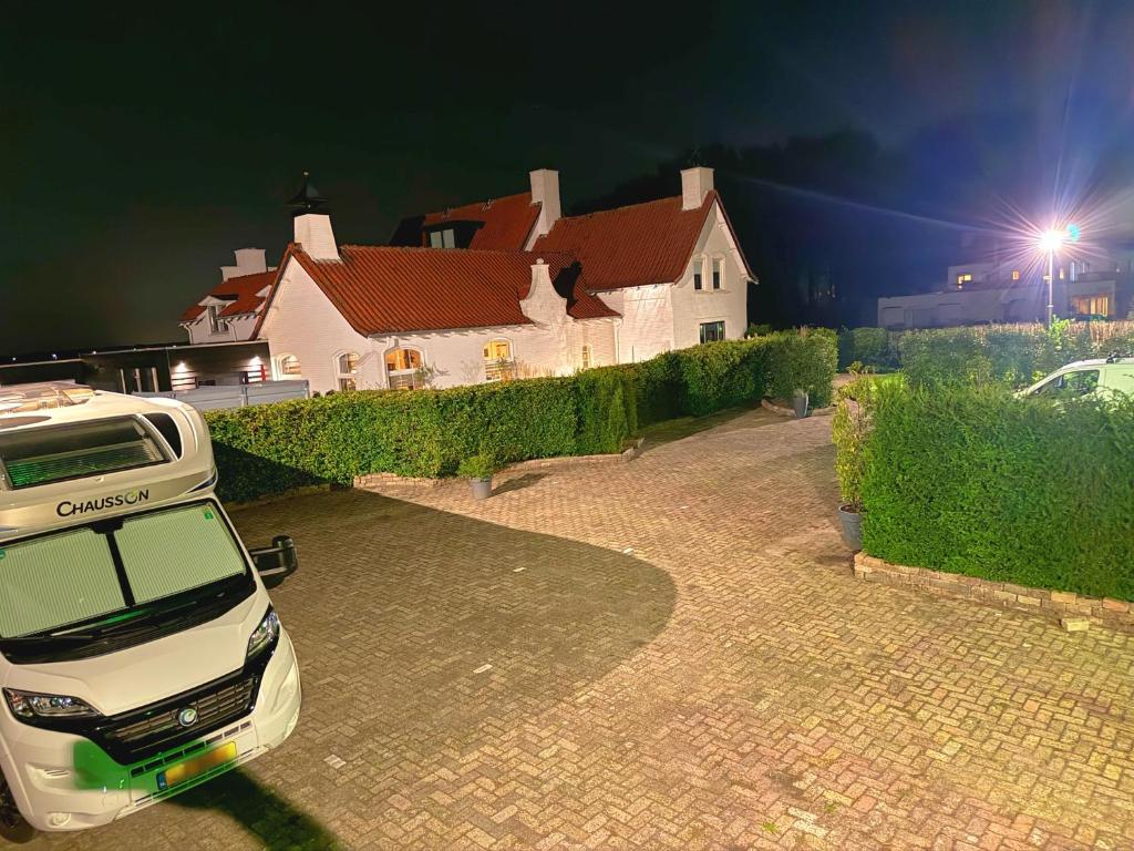 a white car parked in front of a house at Villa Grenszicht in Nispen