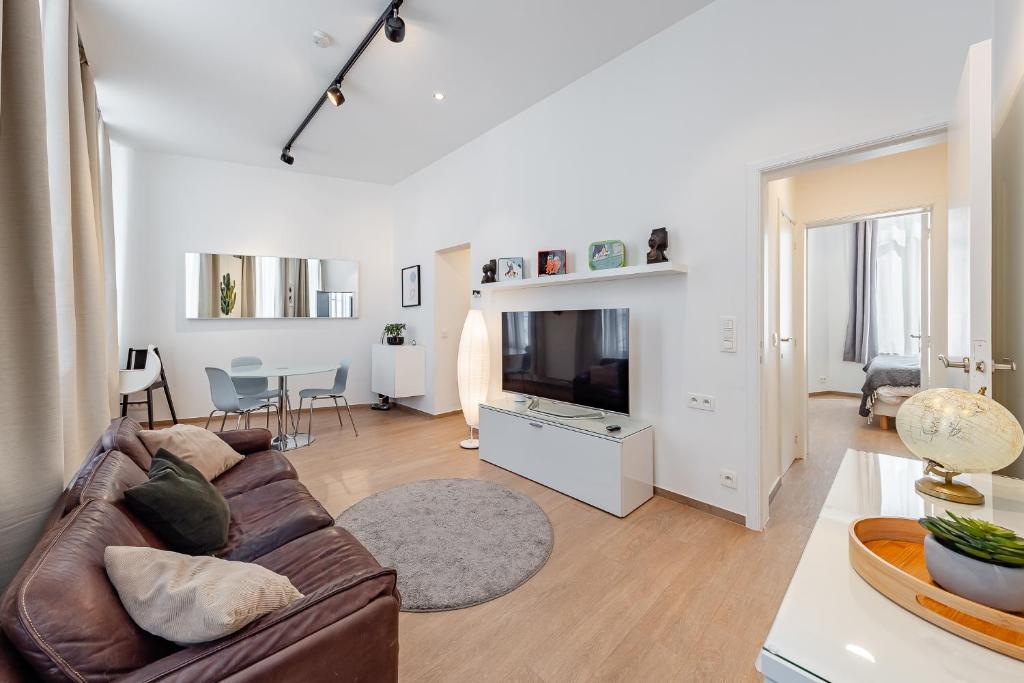 a living room with a couch and a flat screen tv at Fully furnished and modern flat - Brussels center in Brussels