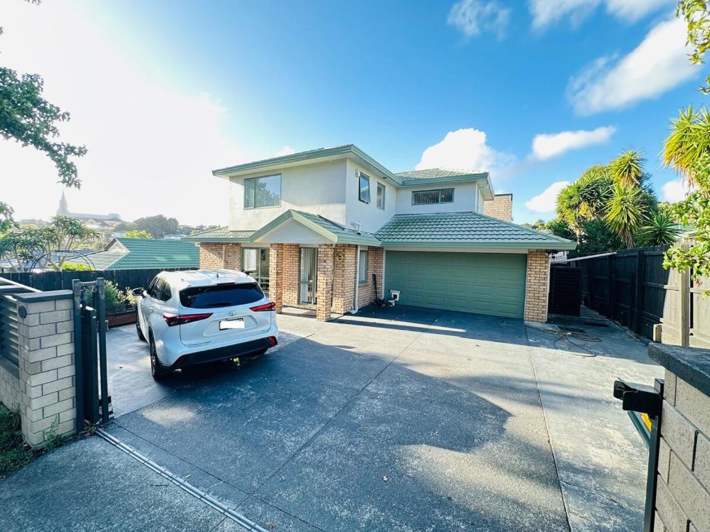a car parked in the driveway of a house at Deluxe Beauty House near Auckland Airport and City in Auckland