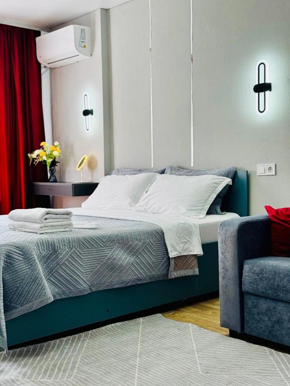 a bedroom with a large bed and a chair at Квартира - Кэнди in Ustʼ-Kamenogorsk