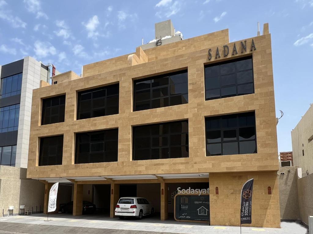 un edificio con un coche aparcado delante en Sadana, en Yeda
