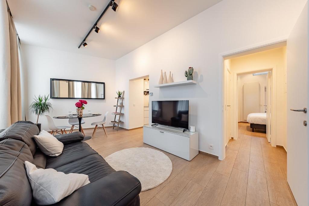 a living room with a couch and a television at Cosy flat in Brussel Center in Mellet