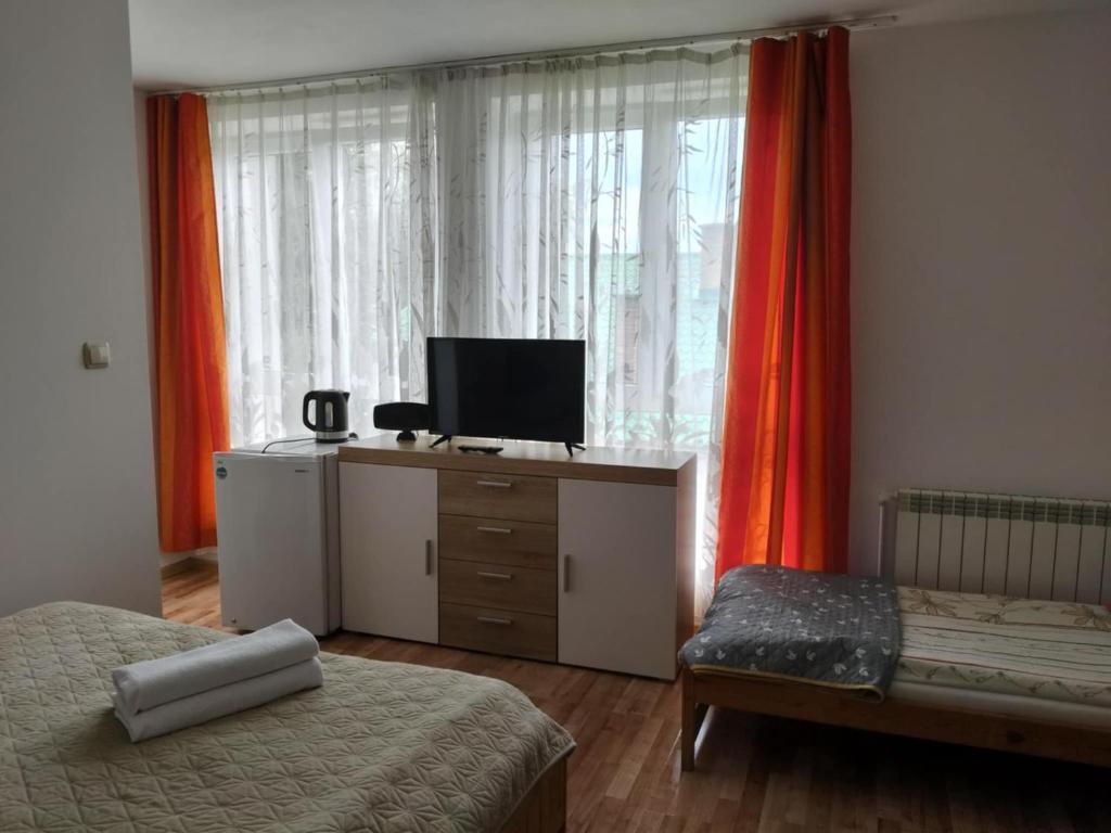 a bedroom with two beds and a desk with a television at Pokoje gościnne Jacek in Polańczyk