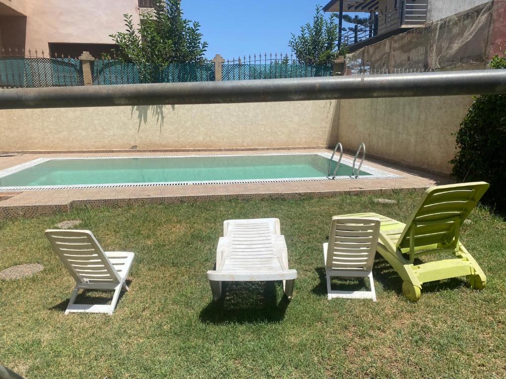 2 sillas, mesa y piscina en Villa for rent in Nouaceur, en Nouaseur