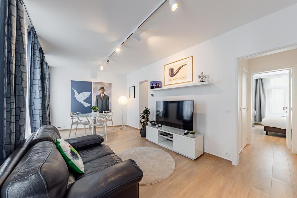 a living room with a couch and a television at Surreal cocoon in Brussels center in Mellet