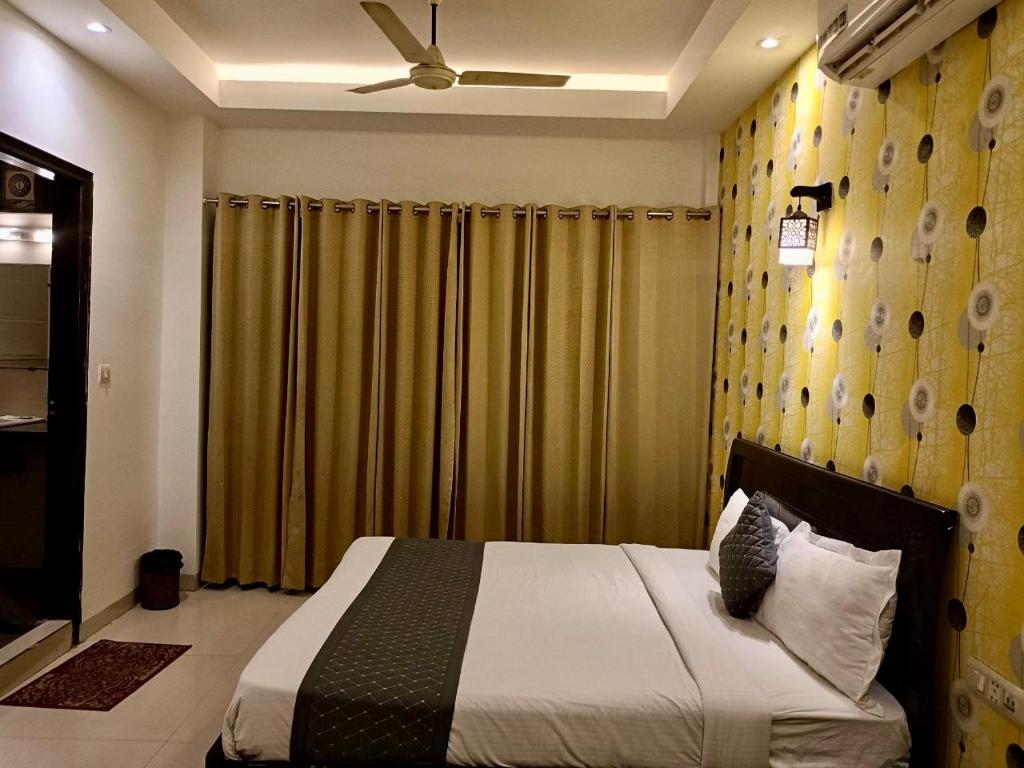 a bedroom with a bed and a ceiling fan at Hotel Delhi Airport Plaza IGI Airport , Free Airport Pickup in New Delhi