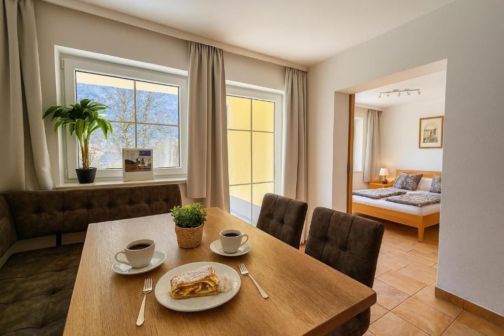 a dining room with a table and chairs and a bedroom at Appartementhaus Flattach in Flattach