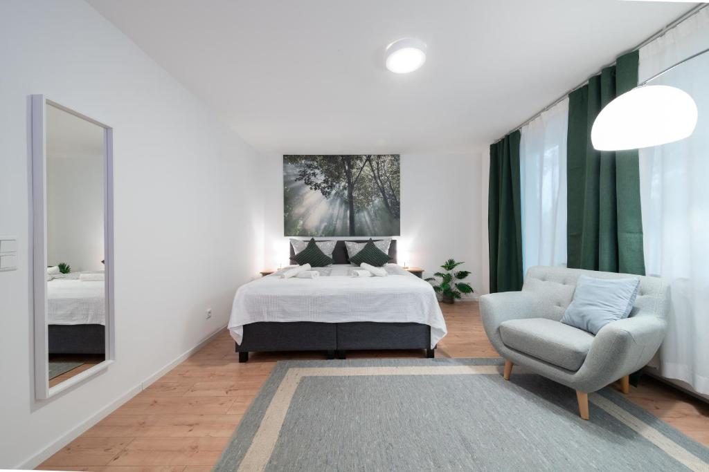 a bedroom with a bed and a chair and a mirror at Central Studio Near Main Train Station & Old City Hall in Wuppertal