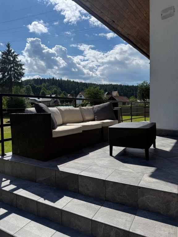 a couch sitting on top of a patio at Dom Letniskowy Sądecczyzna in Olszanka