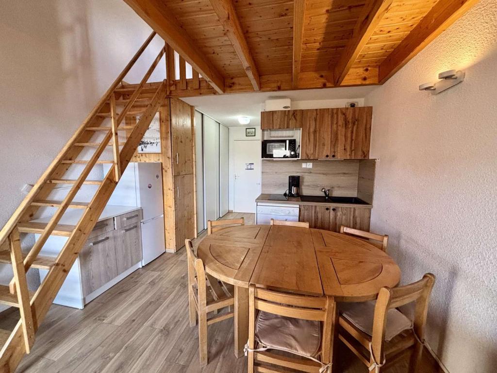 Il comprend une cuisine et une salle à manger avec une table en bois. dans l'établissement Appartement 2 pièces-mezzanine pour 6 pers. avec balcon sud/ouest, skis aux pieds - Huez - FR-1-405-163, à Huez