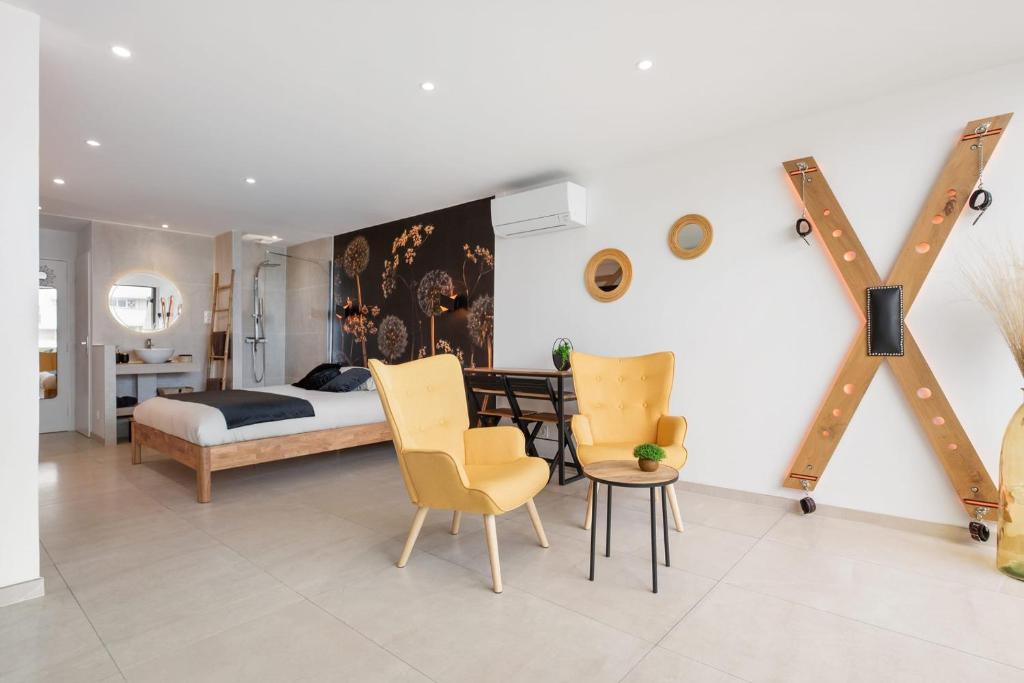 une chambre avec un lit, une table et des chaises dans l'établissement ADDICT Heliopolis, au Cap d'Agde