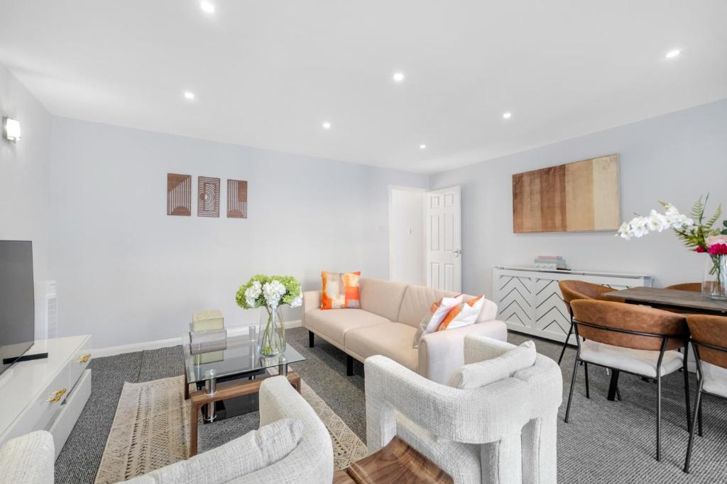 a living room with a couch and a table at Boone - 2 Free Parking,5 minutes walk to Great Southsea Run, 7mins walk to university, Sleeps 1- 7 Comfortably, Driveway, Beach inspired Cozy Garden in Portsmouth
