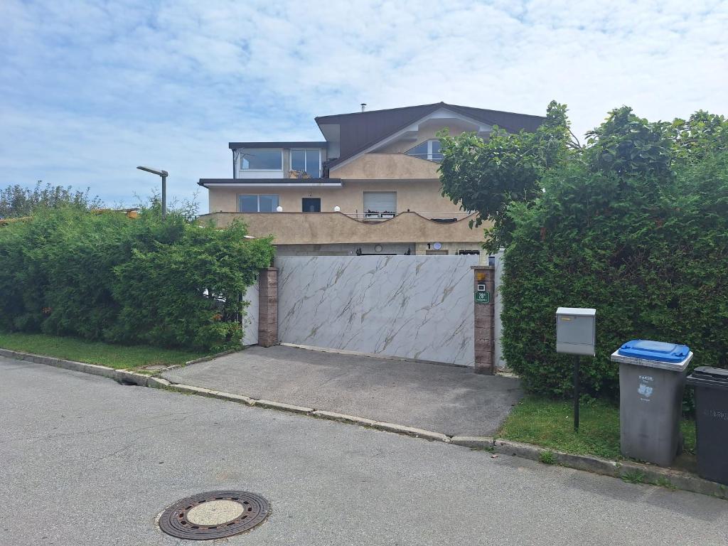 a house with a white garage with a driveway at Apartments Bells of Ljubljana - 3 cosy apartment Private Free Parking in Ljubljana