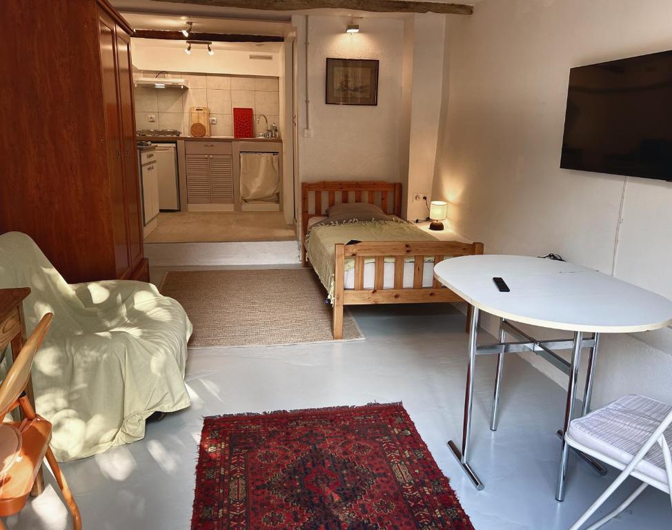 een kleine woonkamer met een bed en een tafel bij Chambre équipée dans appartement de village in Magagnosc