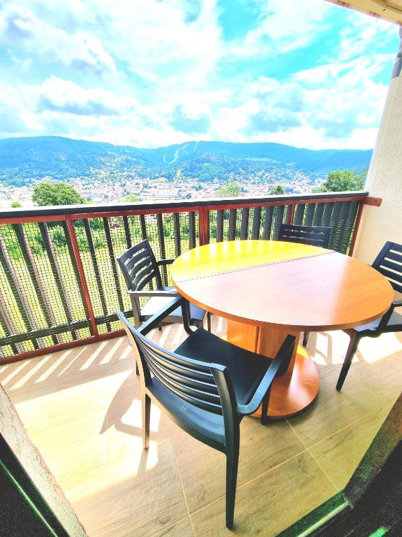 une table et des chaises sur un balcon avec vue dans l'établissement Vacances Gérardmer belle vue et calme, à Gérardmer