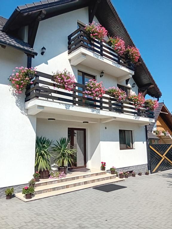 ein weißes Gebäude mit Blumen auf den Balkonen in der Unterkunft Casa Marylo in Bran